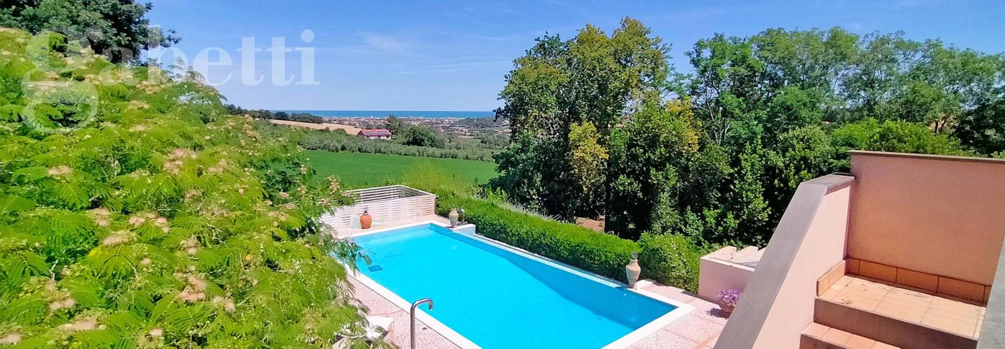Fotografia principale Immobile[SV04679]: SENIGALLIA – In prima collina, in posizione riservata e panoramica, splendida villa di 210 mq con incantevole vista mare e piscina.
La proprietà comprende una dependance di 180 mq con sala biliardo e camino, palestra e SPA, oltre a una caratteristica tavernetta di 76 mq con forno a legna e bagno.
Interamente recintata, è circondata da 1 ettaro di giardino accuratamente piantumato e con circa 30 ulivi.
Finiture di pregio, privacy e comfort rendono questa residenza una soluzione unica a pochi minuti dal mare.